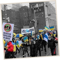 A rally lining a park path, flags held up along its length.