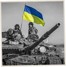 Soldiers on top of a tank with a Ukrainian flag flying above them.